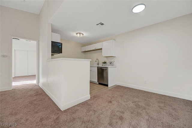 5161 Lindell Rd Unit 206, Las Vegas, NV 89118 - kitchen with dishwasher, light colored carpet, white cabinets, light countertops, and a peninsula