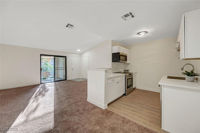 5161 Lindell Rd Unit 206, Las Vegas, NV 89118 - kitchen with stainless steel appliances, open floor plan, white cabinets, light colored carpet, and light countertops