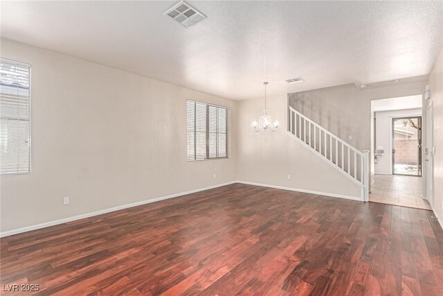 10584 Peach Creek St, Las Vegas, NV 89179 - unfurnished living room with wood finished floors, stairway, and a chandelier