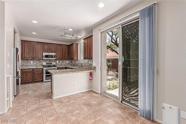 10584 Peach Creek St, Las Vegas, NV 89179 - kitchen featuring appliances with stainless steel finishes, decorative backsplash, a peninsula, recessed lighting, and light stone countertops