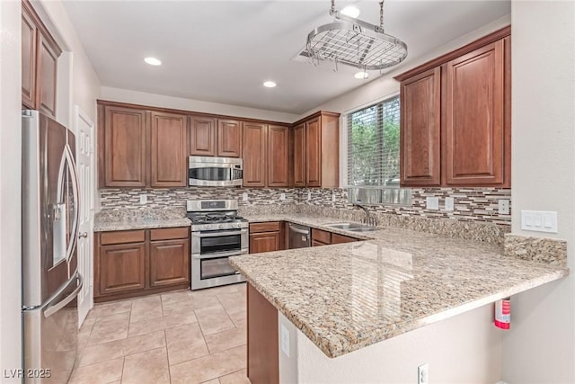 10584 Peach Creek St, Las Vegas, NV 89179 - kitchen with appliances with stainless steel finishes, a peninsula, tasteful backsplash, light stone countertops, and recessed lighting