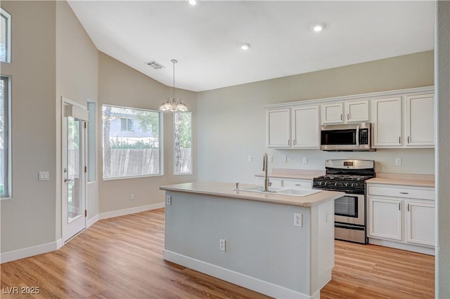 10198 Timber Willow Ave, Las Vegas, NV 89135 - kitchen featuring appliances with stainless steel finishes, lofted ceiling, a chandelier, white cabinets, and light countertops