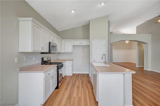 10198 Timber Willow Ave, Las Vegas, NV 89135 - kitchen with appliances with stainless steel finishes, arched walkways, light wood finished floors, light countertops, and lofted ceiling