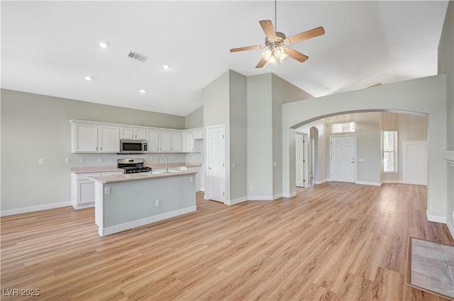 10198 Timber Willow Ave, Las Vegas, NV 89135 - unfurnished living room featuring arched walkways, high vaulted ceiling, a ceiling fan, and light wood finished floors