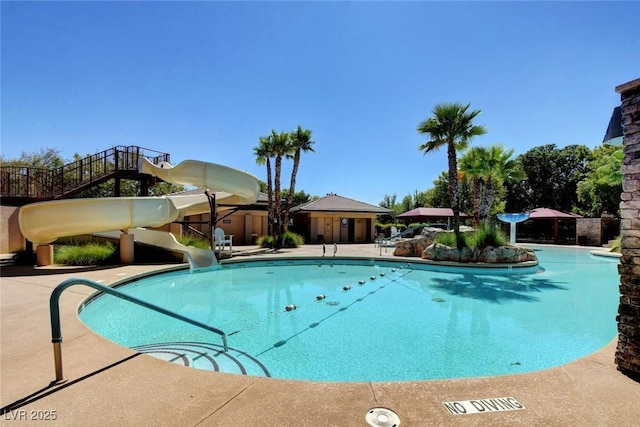 10198 Timber Willow Ave, Las Vegas, NV 89135 - community pool with a water slide and a patio
