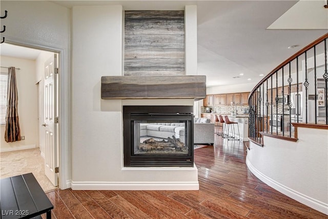 1717 Jake Andrew Ave, North Las Vegas, NV 89086 - unfurnished living room with stairway, wood finished floors, a multi sided fireplace, and recessed lighting