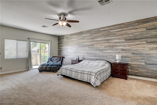 1717 Jake Andrew Ave, North Las Vegas, NV 89086 - bedroom featuring an accent wall, access to outside, carpet, wooden walls, and a ceiling fan
