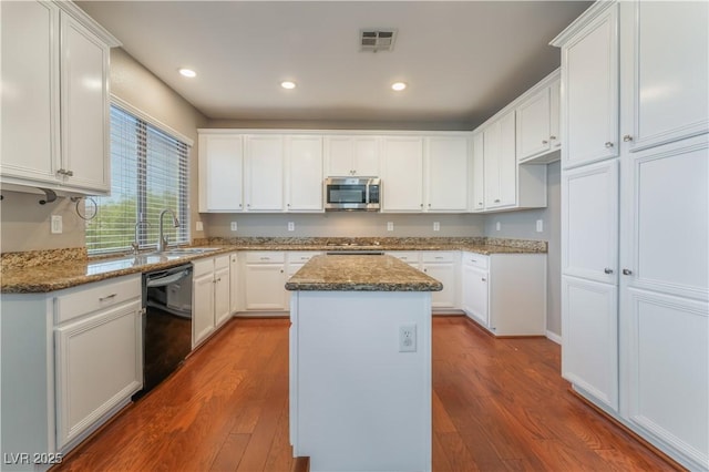 11901 Luna Del Mar Ln, Las Vegas, NV 89138 - kitchen with black dishwasher, stainless steel microwave, dark wood-type flooring, a center island, and dark stone counters