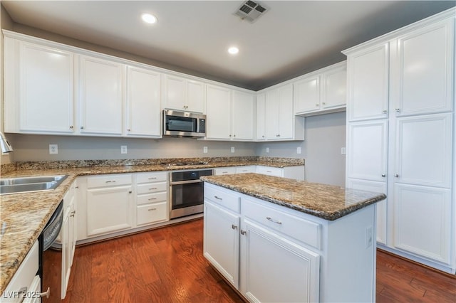 11901 Luna Del Mar Ln, Las Vegas, NV 89138 - kitchen with stainless steel appliances, dark wood-style floors, white cabinets, a center island, and recessed lighting