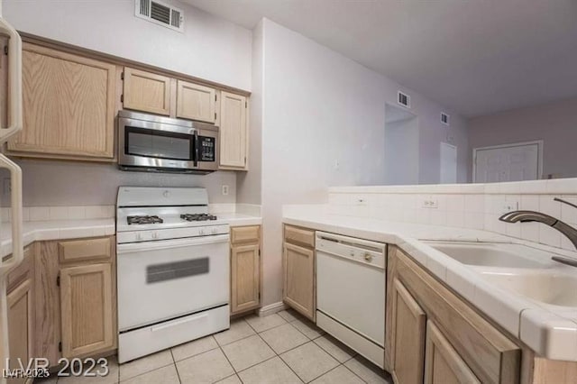 5415 W Harmon Ave Unit 1162, Las Vegas, NV 89103 - kitchen featuring white appliances, tile countertops, and light tile patterned floors