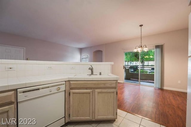 5415 W Harmon Ave Unit 1162, Las Vegas, NV 89103 - kitchen with dishwasher, tile counters, backsplash, light tile patterned floors, and a chandelier