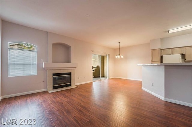 5415 W Harmon Ave Unit 1162, Las Vegas, NV 89103 - unfurnished living room featuring a chandelier, a tiled fireplace, and wood-type flooring