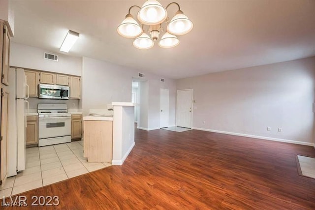 5415 W Harmon Ave Unit 1162, Las Vegas, NV 89103 - kitchen featuring white appliances, light countertops, open floor plan, a chandelier, and light wood-style floors