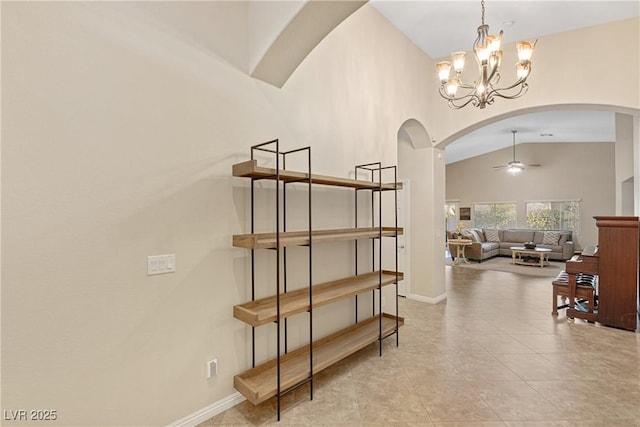 6413 White Tiger Ct, Las Vegas, NV 89130 - stairs with arched walkways, a ceiling fan, vaulted ceiling, tile patterned floors, and a chandelier