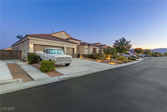 6413 White Tiger Ct, Las Vegas, NV 89130 - view of front of property with an attached garage, driveway, stucco siding, and a tiled roof