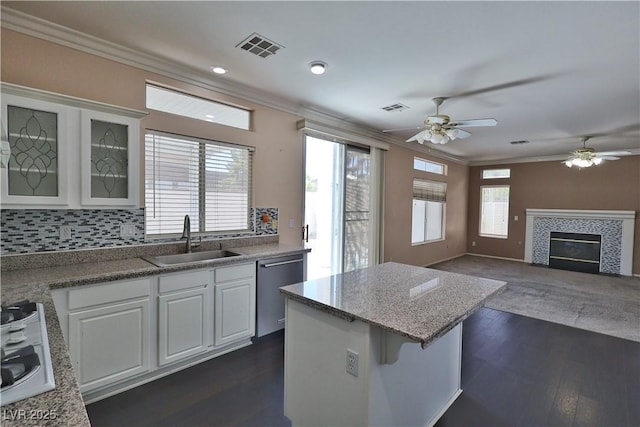975 Leadville Meadows Dr, Henderson, NV 89052 - kitchen featuring crown molding, stainless steel dishwasher, a ceiling fan, white cabinetry, and a kitchen island