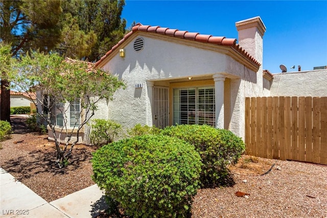 5424 Geneive Ln Unit 105, Las Vegas, NV 89108 - view of side of property featuring stucco siding, a tile roof, and a chimney