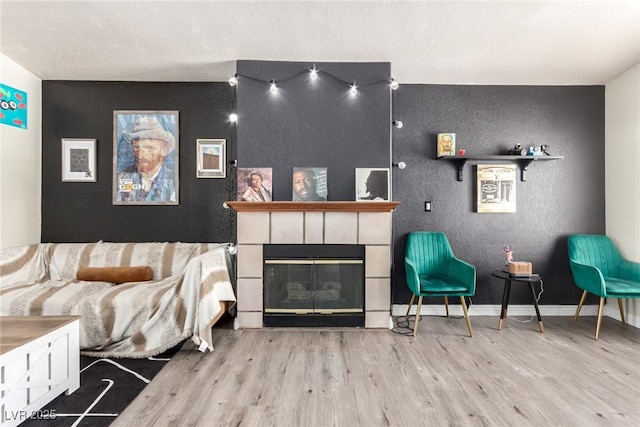 5424 Geneive Ln Unit 105, Las Vegas, NV 89108 - living area featuring wood finished floors, a textured wall, and a tile fireplace