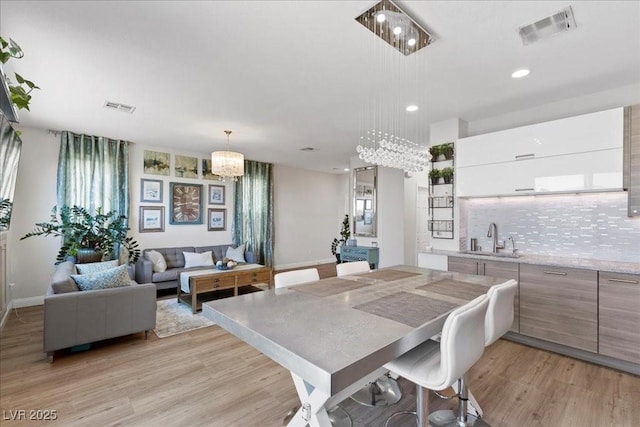 694 Value Ridge Ave, Henderson, NV 89012 - dining area with light wood-type flooring, a chandelier, recessed lighting, and healthy amount of natural light