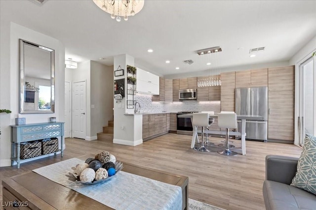 694 Value Ridge Ave, Henderson, NV 89012 - living area featuring light wood-style floors, recessed lighting, stairway, and a chandelier