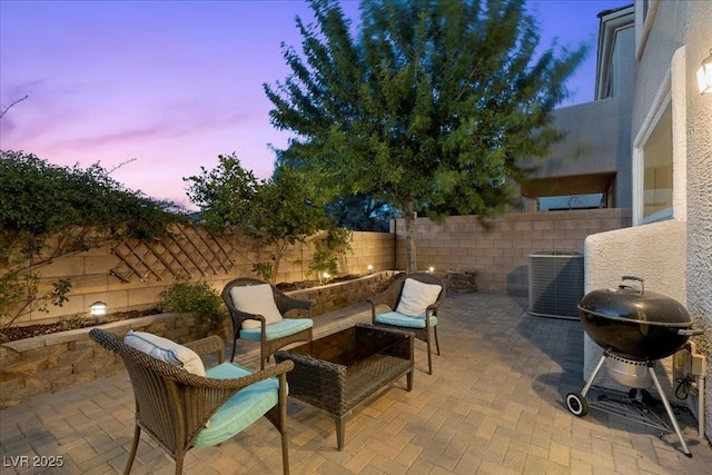694 Value Ridge Ave, Henderson, NV 89012 - patio terrace at dusk featuring a fenced backyard, a patio area, and grilling area