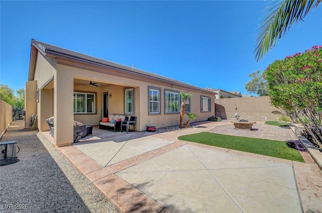 2779 Kindeace Ave, Henderson, NV 89044 - rear view of house with an outdoor living space with a fire pit, a patio, stucco siding, and ceiling fan
