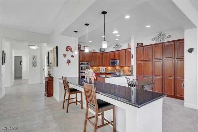 2779 Kindeace Ave, Henderson, NV 89044 - kitchen featuring stainless steel appliances, dark countertops, decorative backsplash, decorative light fixtures, and recessed lighting