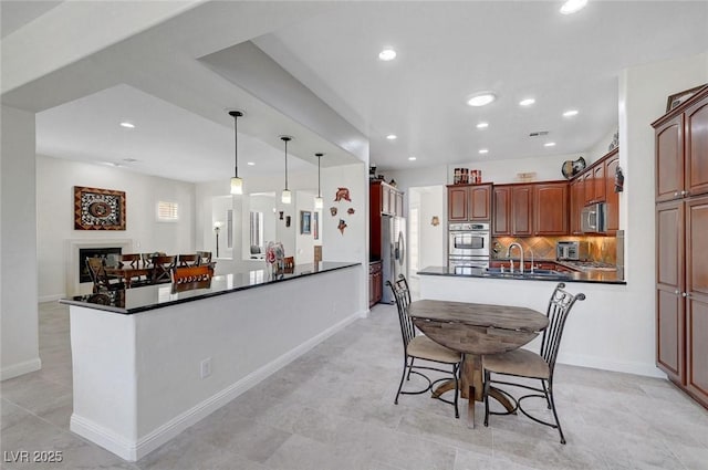 2779 Kindeace Ave, Henderson, NV 89044 - kitchen featuring a peninsula, stainless steel microwave, dark countertops, fridge with ice dispenser, and recessed lighting
