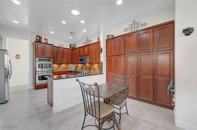 2779 Kindeace Ave, Henderson, NV 89044 - kitchen featuring appliances with stainless steel finishes, recessed lighting, decorative backsplash, dark countertops, and a peninsula