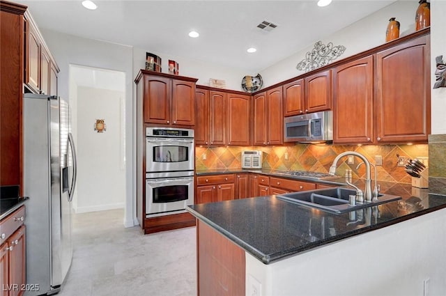 2779 Kindeace Ave, Henderson, NV 89044 - kitchen featuring appliances with stainless steel finishes, a peninsula, decorative backsplash, recessed lighting, and dark stone countertops