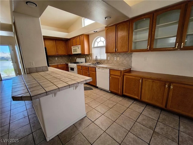 9693 Bighorn Island Ave, Las Vegas, NV 89148 - kitchen with white appliances, tile countertops, a peninsula, backsplash, and light tile patterned floors