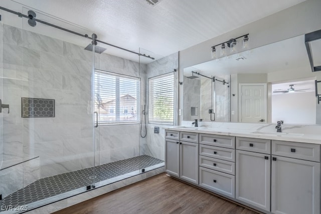 7619 Comanche Canyon Ave, Las Vegas, NV 89113 - bathroom with a shower stall, double vanity, wood finished floors, and a ceiling fan