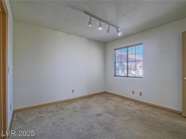 1409 Santa Margarita St Unit G, Las Vegas, NV 89146 - unfurnished room with rail lighting, carpet floors, and a textured ceiling