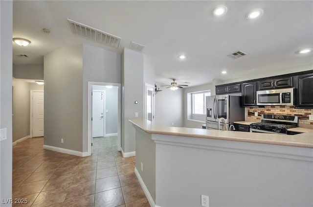 5732 Hornbrook St, North Las Vegas, NV 89031 - kitchen with stainless steel appliances, light countertops, dark cabinetry, tasteful backsplash, and a ceiling fan