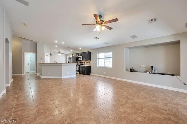 5732 Hornbrook St, North Las Vegas, NV 89031 - unfurnished living room with a ceiling fan, light tile patterned flooring, arched walkways, and recessed lighting