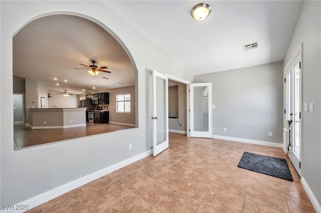 5732 Hornbrook St, North Las Vegas, NV 89031 - foyer with french doors, arched walkways, a ceiling fan, and light tile patterned flooring