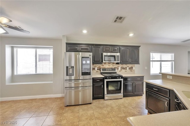 5732 Hornbrook St, North Las Vegas, NV 89031 - kitchen featuring appliances with stainless steel finishes, ceiling fan, light countertops, tasteful backsplash, and light tile patterned floors