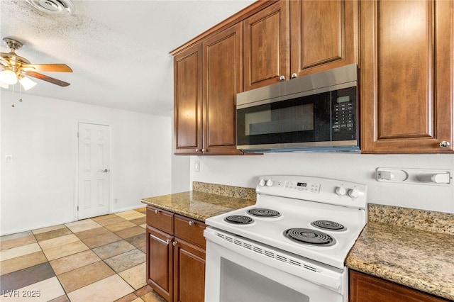 1901 Manhattan Dr, Las Vegas, NV 89106 - kitchen with stainless steel microwave, white range with electric cooktop, a ceiling fan, and brown cabinetry