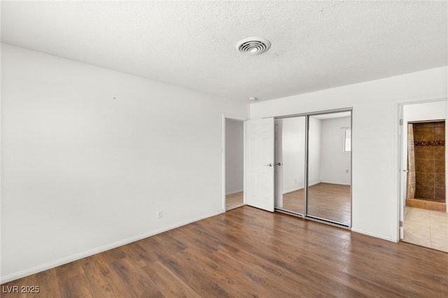 1901 Manhattan Dr, Las Vegas, NV 89106 - unfurnished bedroom featuring wood finished floors, a closet, and a textured ceiling