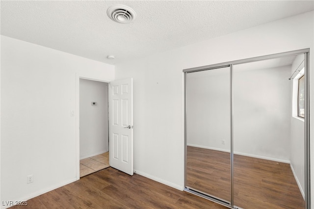 1901 Manhattan Dr, Las Vegas, NV 89106 - unfurnished bedroom featuring wood finished floors, a closet, and a textured ceiling