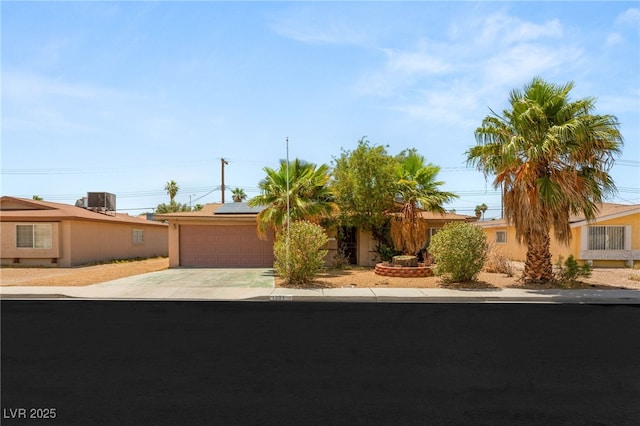 1901 Manhattan Dr, Las Vegas, NV 89106 - view of front of house featuring concrete driveway, an attached garage, solar panels, and stucco siding