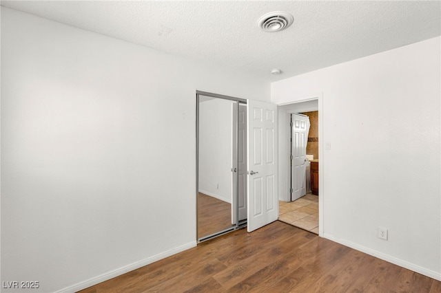 1901 Manhattan Dr, Las Vegas, NV 89106 - unfurnished bedroom featuring wood finished floors, a closet, and a textured ceiling
