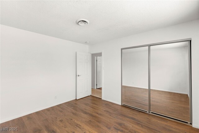 1901 Manhattan Dr, Las Vegas, NV 89106 - unfurnished bedroom featuring wood finished floors, a closet, and a textured ceiling