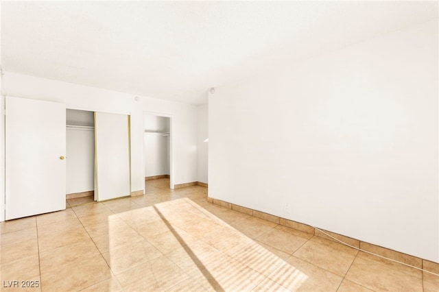 3668 Villa Knolls E Dr, Las Vegas, NV 89120 - unfurnished bedroom with light tile patterned flooring and multiple closets
