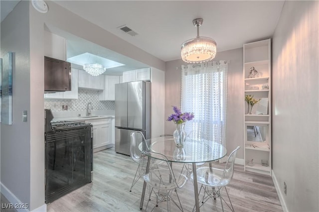 5219 Caliente St Unit 11, Las Vegas, NV 89119 - dining room with a chandelier and light wood-style floors