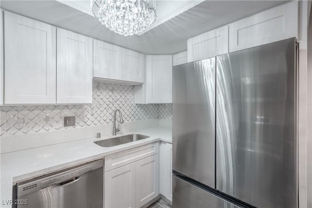 5219 Caliente St Unit 11, Las Vegas, NV 89119 - kitchen featuring appliances with stainless steel finishes, white cabinets, light countertops, and backsplash