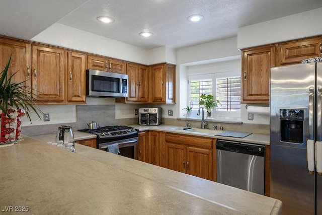 9357 Golden Timber Ln, Las Vegas, NV 89117 - kitchen featuring appliances with stainless steel finishes, brown cabinetry, light countertops, backsplash, and recessed lighting