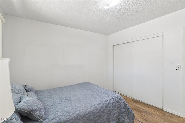 4027 Maple Hill Rd, Las Vegas, NV 89115 - bedroom featuring wood finished floors, a closet, and a textured ceiling