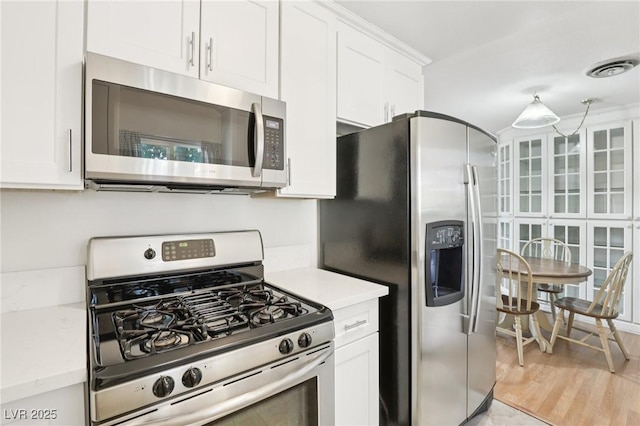 4027 Maple Hill Rd, Las Vegas, NV 89115 - kitchen with stainless steel appliances, light countertops, and white cabinets