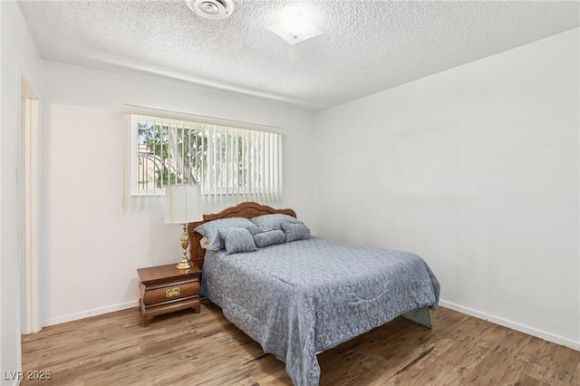 4027 Maple Hill Rd, Las Vegas, NV 89115 - bedroom featuring wood finished floors and a textured ceiling